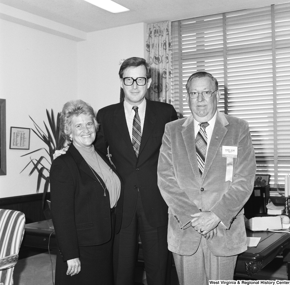 ["Senator John D. (Jay) Rockefeller stands in front of the desk in his office and stands with two representatives from the National Association of Home Builders. One is unidentified, but the other has a name badge that identifies him as Henry King of Charleston, West Virginia."]%