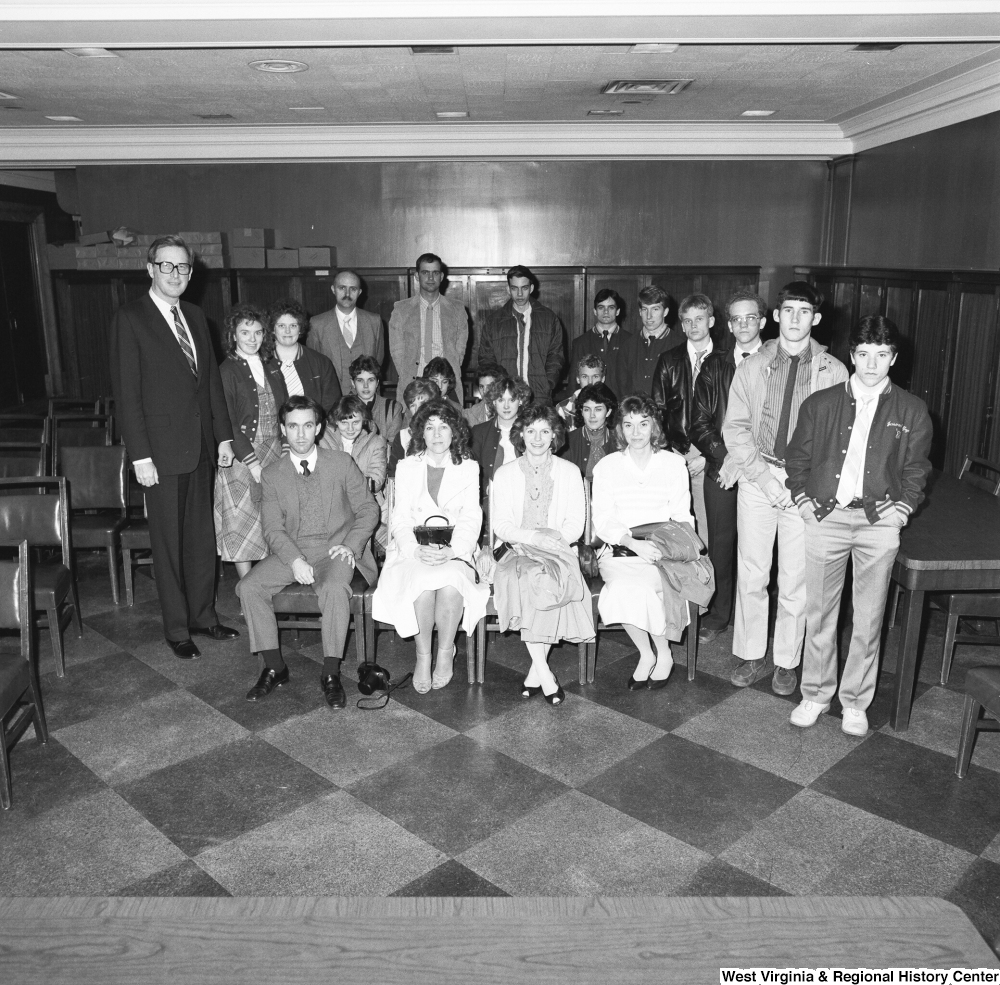 ["Senator John D. (Jay) Rockefeller stands for a photograph with a large unidentified group in a Senate office building."]%