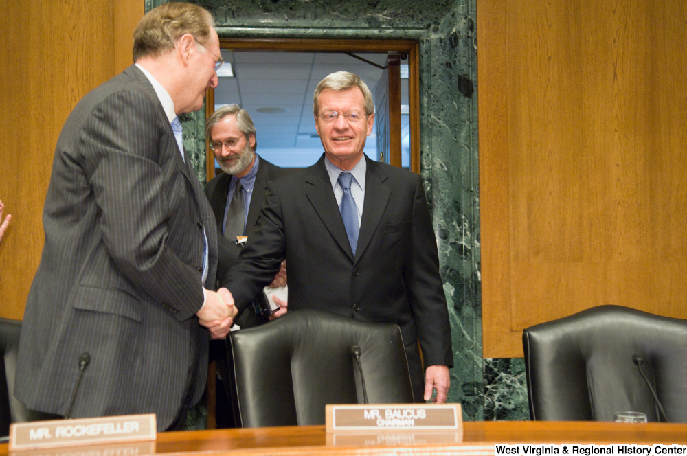 ["Senator John D. (Jay) Rockefeller shakes hands with Senator Max Baucus as he approaches his chair at a Senate Finance Committee hearing."]%