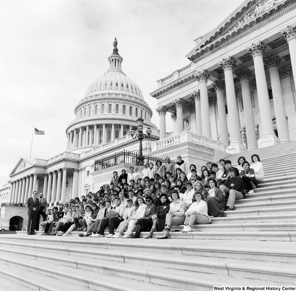 ["Senator John D. (Jay) Rockefeller poses for a photograph on the U.S. Capitol steps with a large student group."]%
