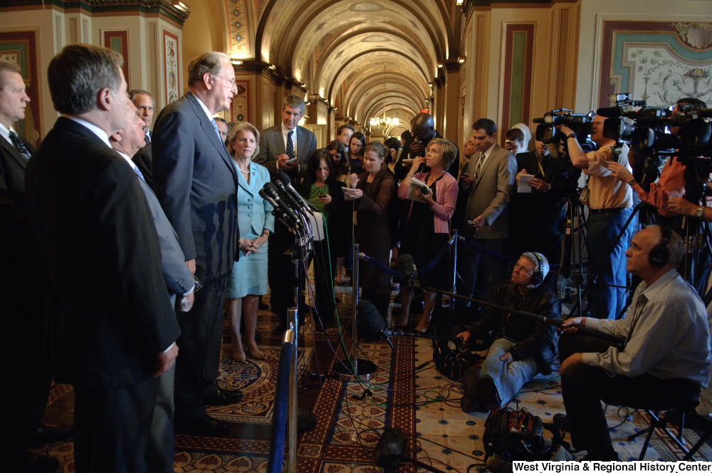 ["Senator John D. (Jay) Rockefeller speaks at a press event in a hallway outside the Senate."]%
