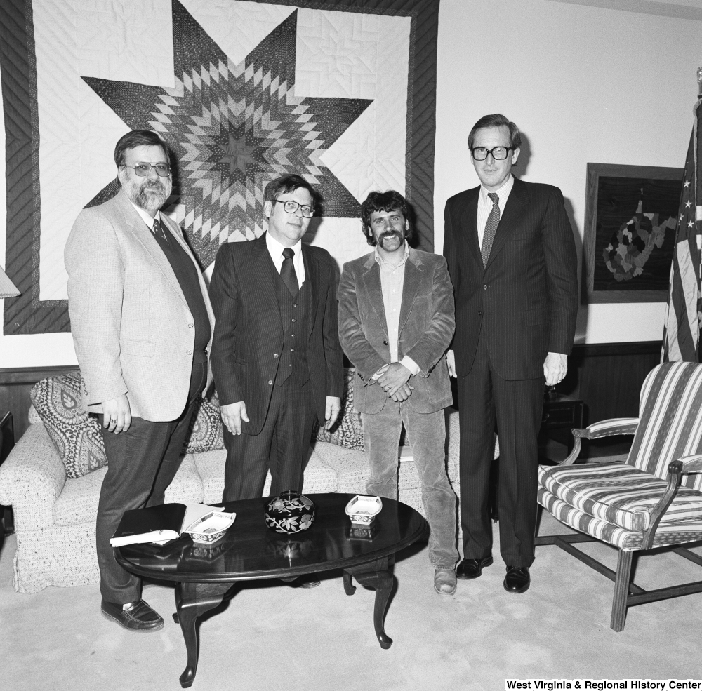 ["Senator John D. (Jay) Rockefeller stands for a photograph with three unidentified individuals in his Washington office."]%