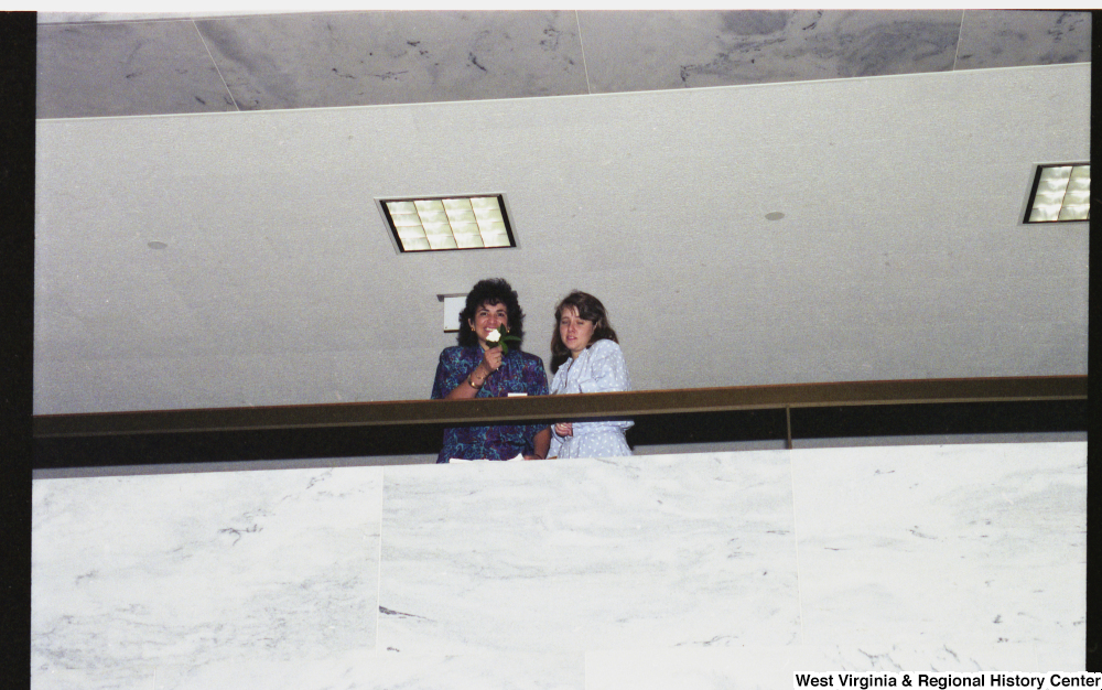 ["Two unidentified young women stand in a hallway in the Hart Building."]%
