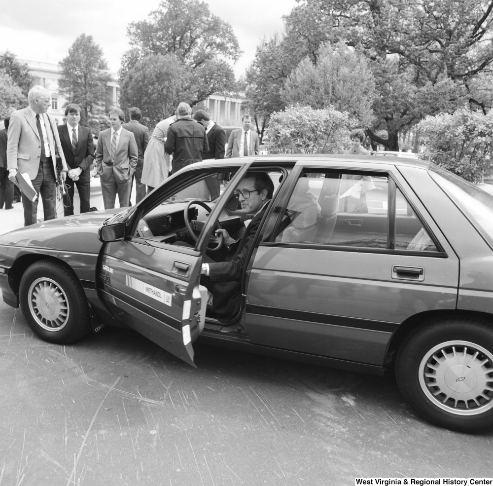 ["Senator John D. (Jay) Rockefeller exits a General Motors gasoline/methanol car outside the Senate."]%