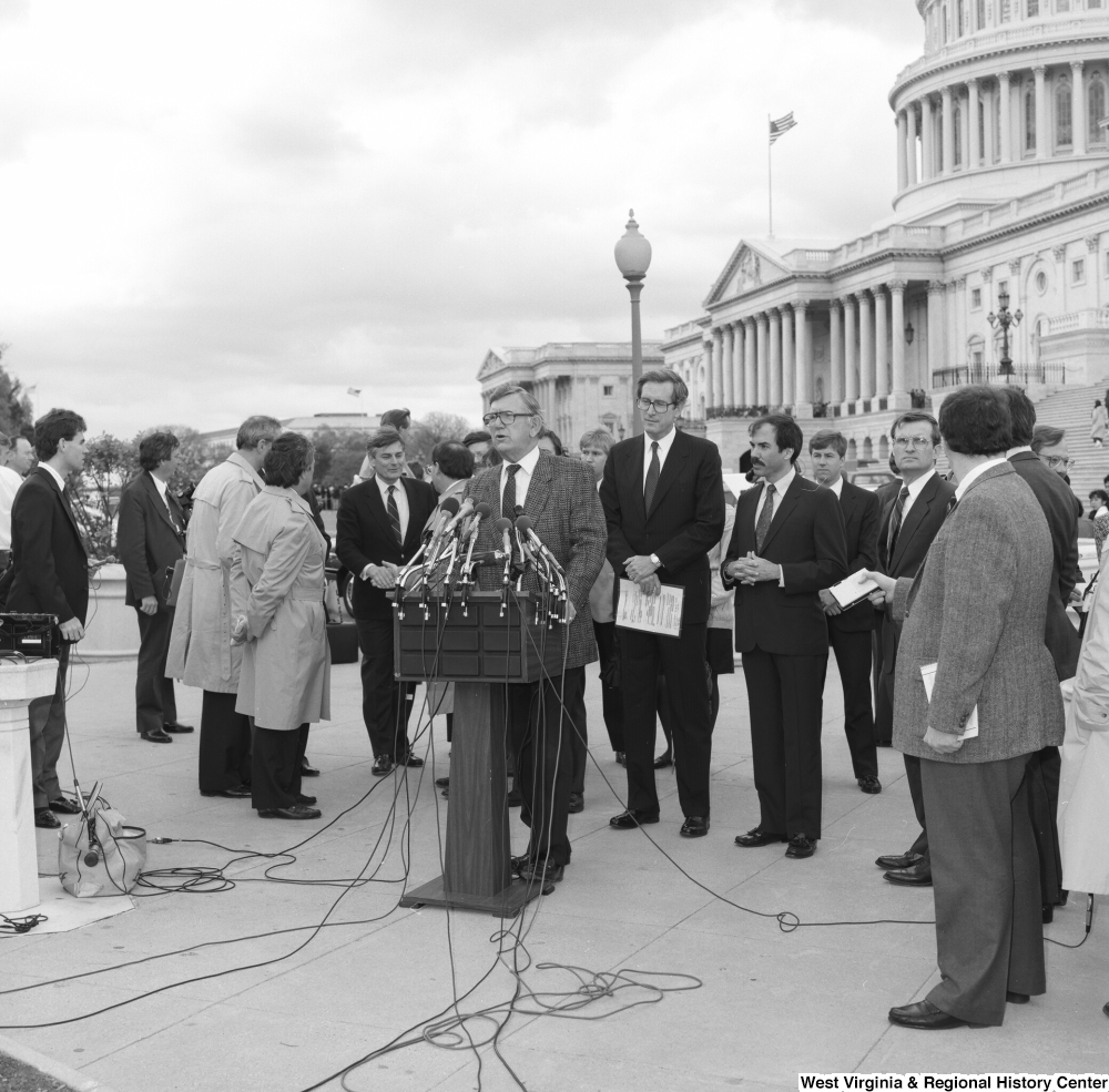 ["A man speaks to the press at an event outside the Senate building."]%