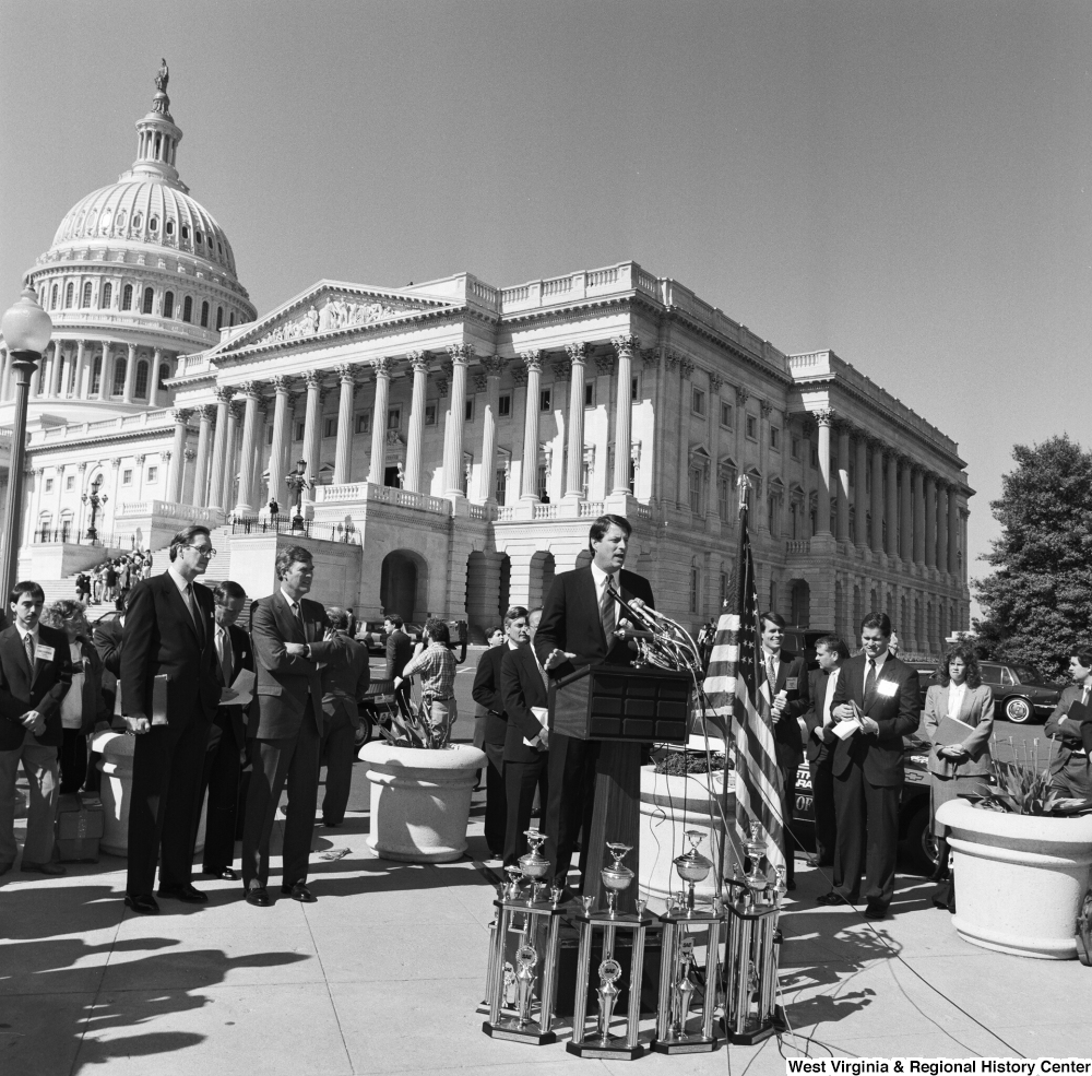 ["Senator Al Gore stands and speaks to an audience outside the Senate during a clean vehicle event."]%