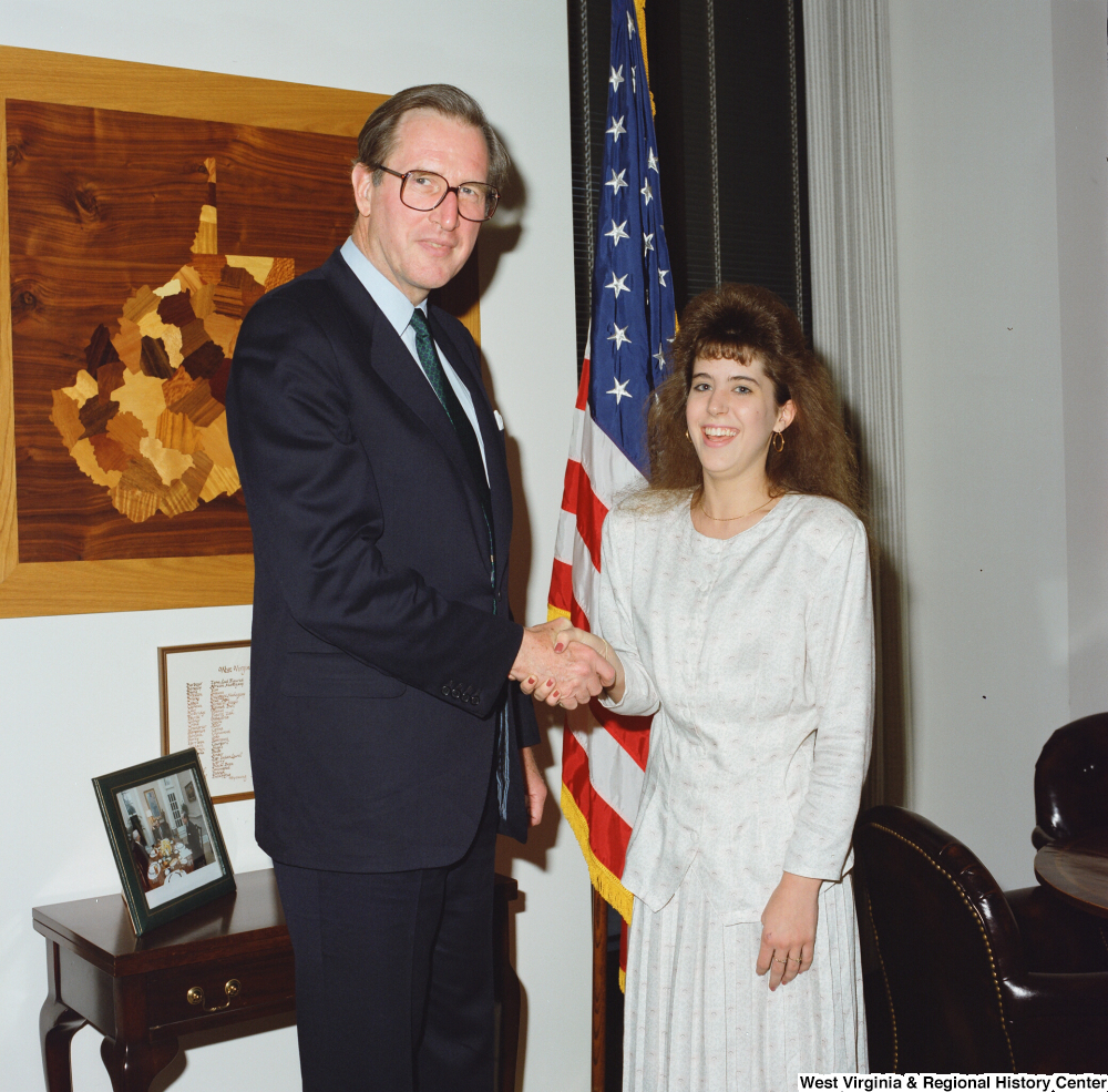 ["Senator John D. (Jay) Rockefeller shakes hands with a young woman in his office."]%