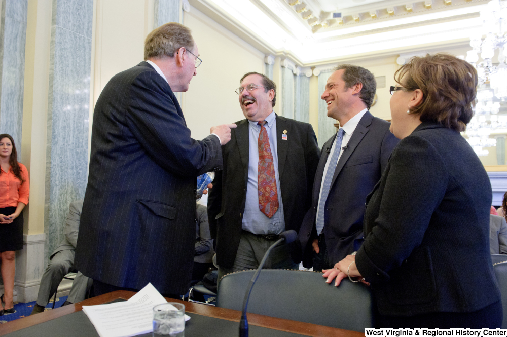 ["Senator John D. (Jay) Rockefeller and tv personality Mike Rowe laugh before a Commerce Committee hearing."]%