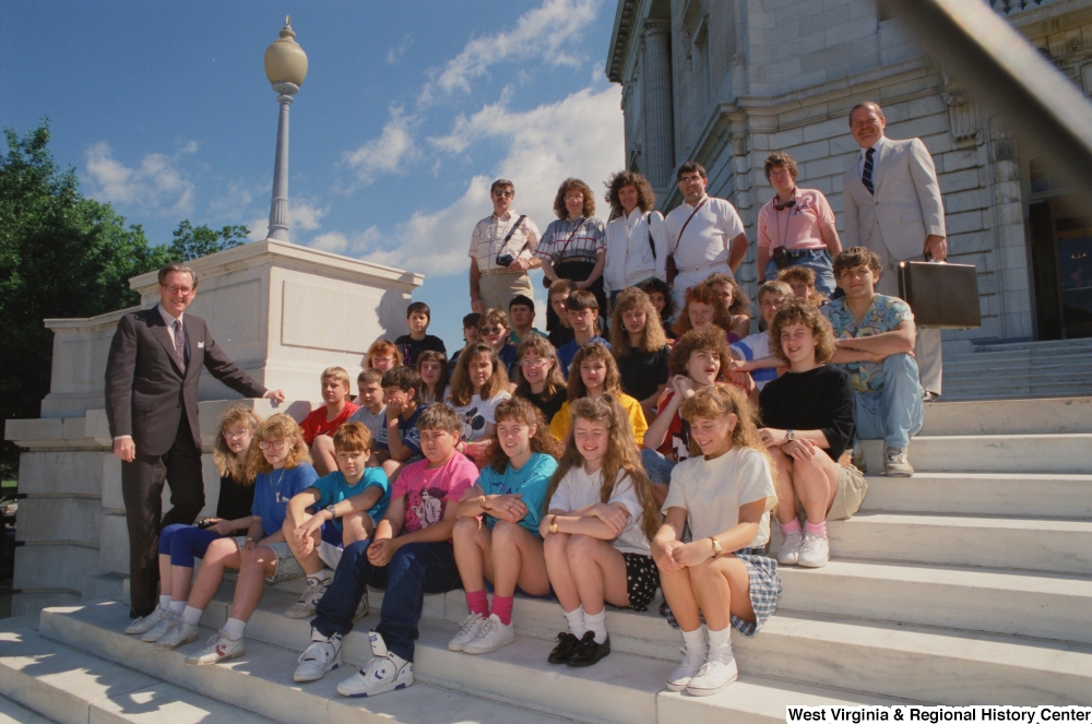 ["Senator John D. (Jay) Rockefeller stands with a group of West Virginia students on the steps of the Senate."]%
