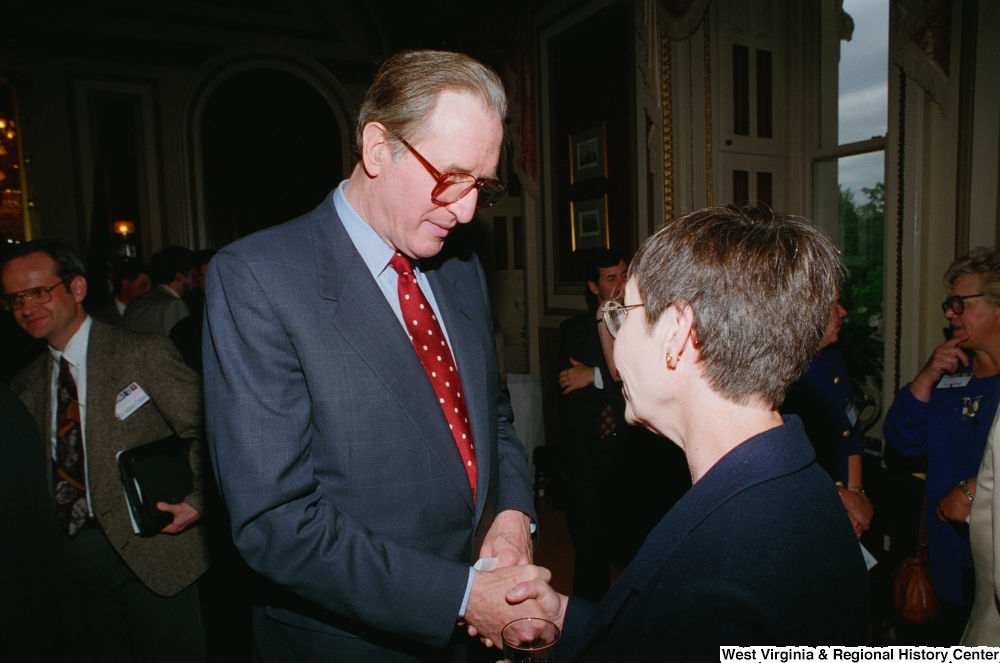 ["Senator John D. (Jay) Rockefeller shakes hands with an unidentified woman at a Celebrating Telemedicine conference."]%