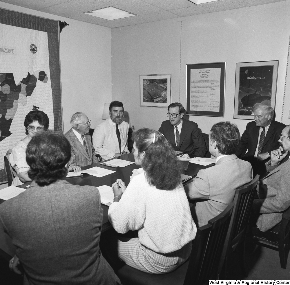 ["Senator John D. (Jay) Rockefeller sits around a conference table in his office at a planning meeting for the Blackwater Canyon Railroad project."]%
