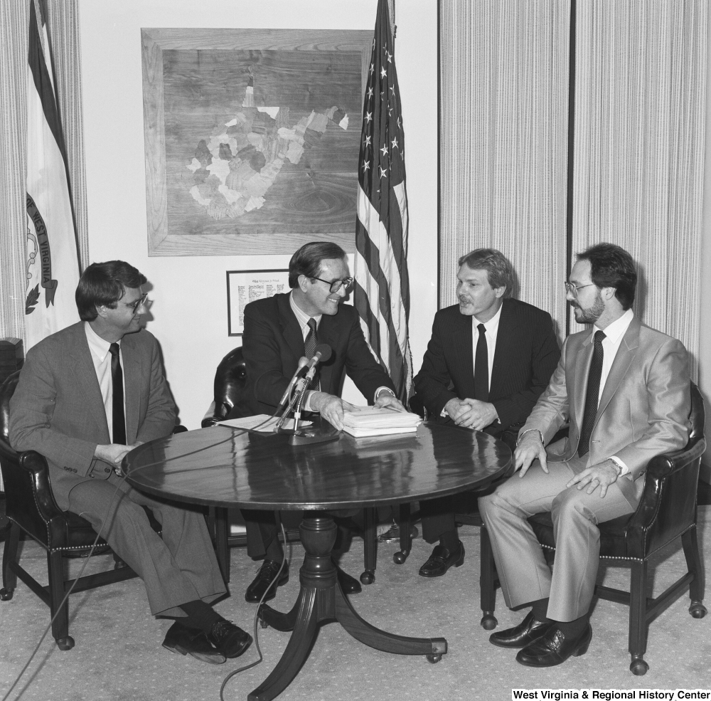 ["Senator John D. (Jay) Rockefeller finishes a business meeting in his office with three steel industry representatives."]%
