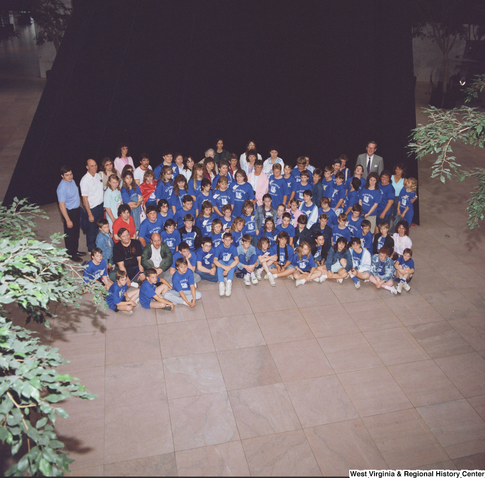 ["Senator John D. (Jay) Rockefeller stands with a group of students in the Hart Building."]%