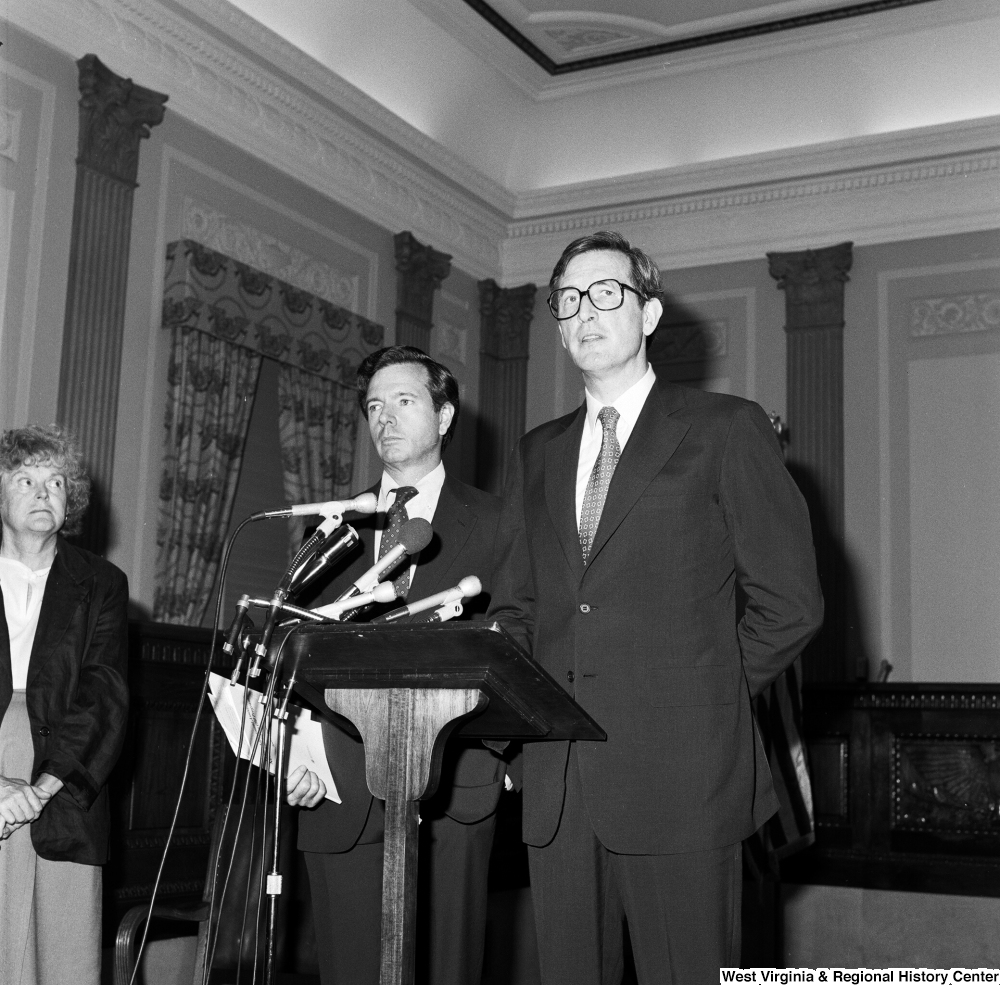 ["Senator John D. (Jay) Rockefeller stands behind a podium with Senator John Heinz at his side."]%