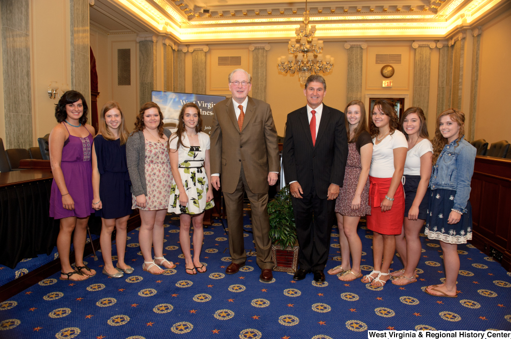 ["Senators John D. (Jay) Rockefeller and Joe Manchin stand with a group of girls in the Senate."]%