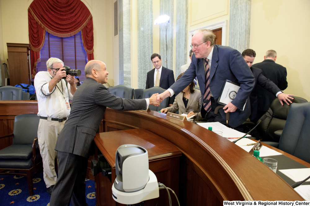 ["Senator John D. (Jay) Rockefeller shakes hands with an unidentified man after a Commerce Committee hearing."]%