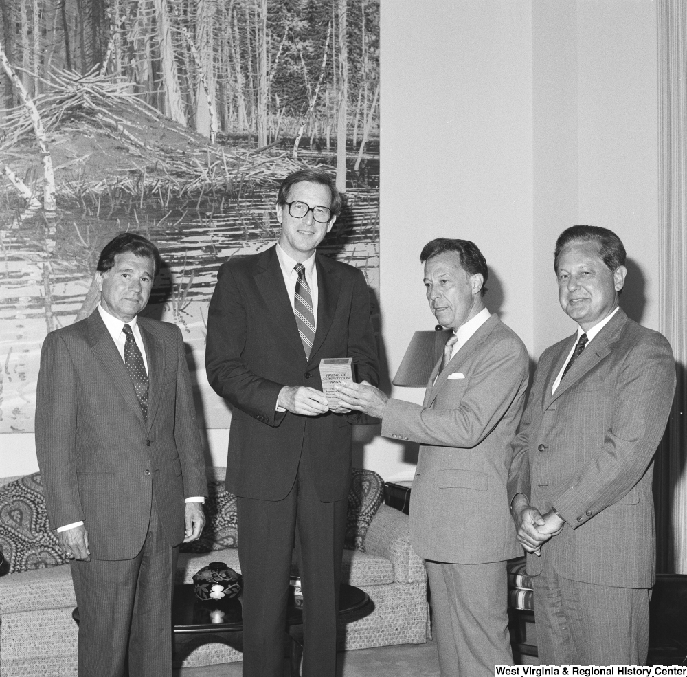 ["Three representatives from the Procompetitive Rail Steering Committee hand Senator John D. (Jay) Rockefeller an award titled the \"Friend of Competition Award\". He was given the award for his work to increase railroad competition and for his leadership in bringing the Consumer Rail Equity Act before Congress."]%