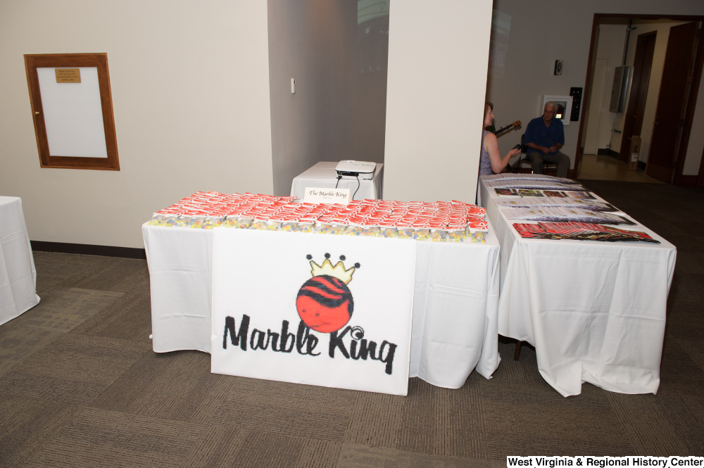 ["The Marble King company has a table at the 150th birthday celebration for West Virginia."]%