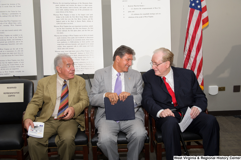 ["Senators John D. (Jay) Rockefeller and Joe Manchin sit with Representative Rahall at the 150th birthday celebration for West Virginia."]%