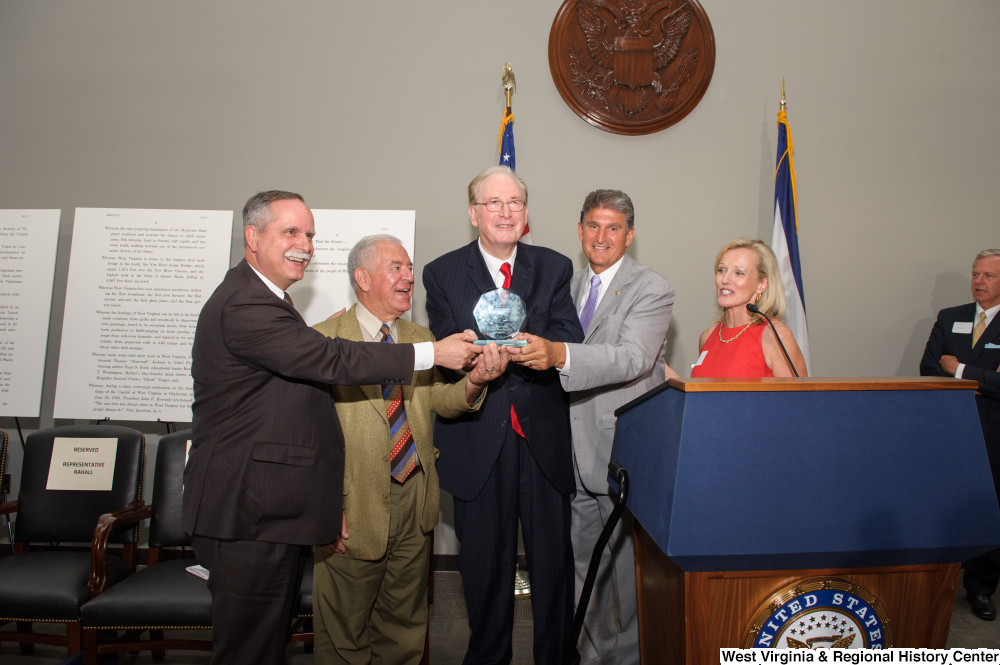 ["Some of West Virginia's Congressional delegation holding an award at the state's 150th birthday celebration."]%
