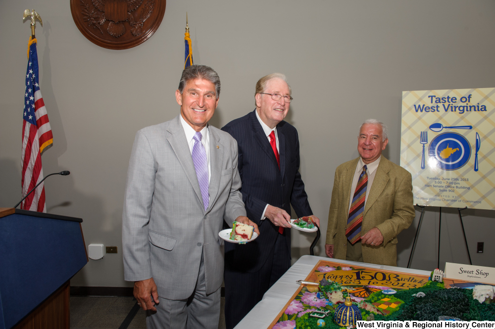 ["Senators John D. (Jay) Rockefeller and Joe Manchin hold pieces of cake during the 150th birthday celebration for West Virginia."]%
