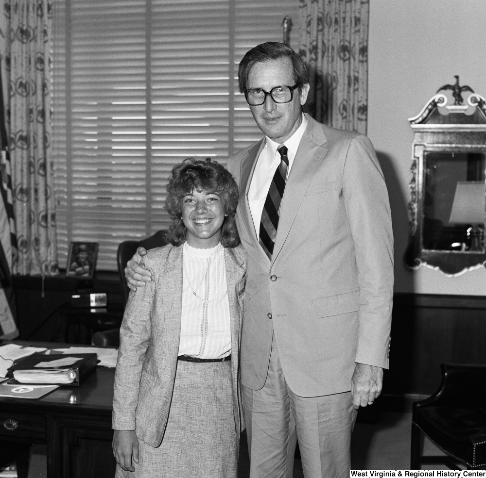["Senator Rockefeller poses for a photograph and embraces an unidentified guest in his Washington office."]%