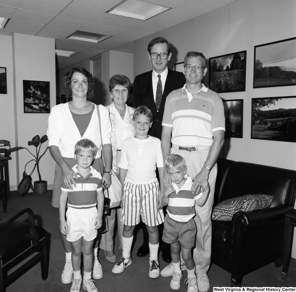 ["Senator John D. (Jay) Rockefeller stands in his office with a young family."]%