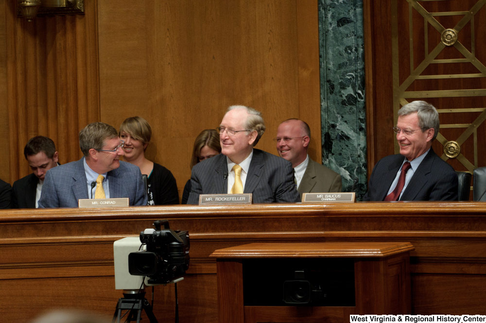 ["Senators John D. (Jay) Rockefeller, Kent Conrad, and Max Baucus share a smile during a Finance Committee hearing."]%