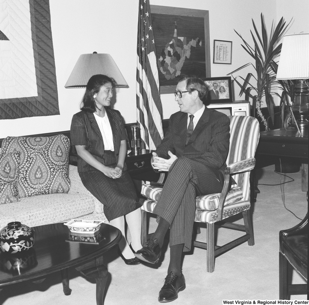 ["Senator John D. (Jay) Rockefeller sits in a chair and speaks with an unidentified guest in his office."]%