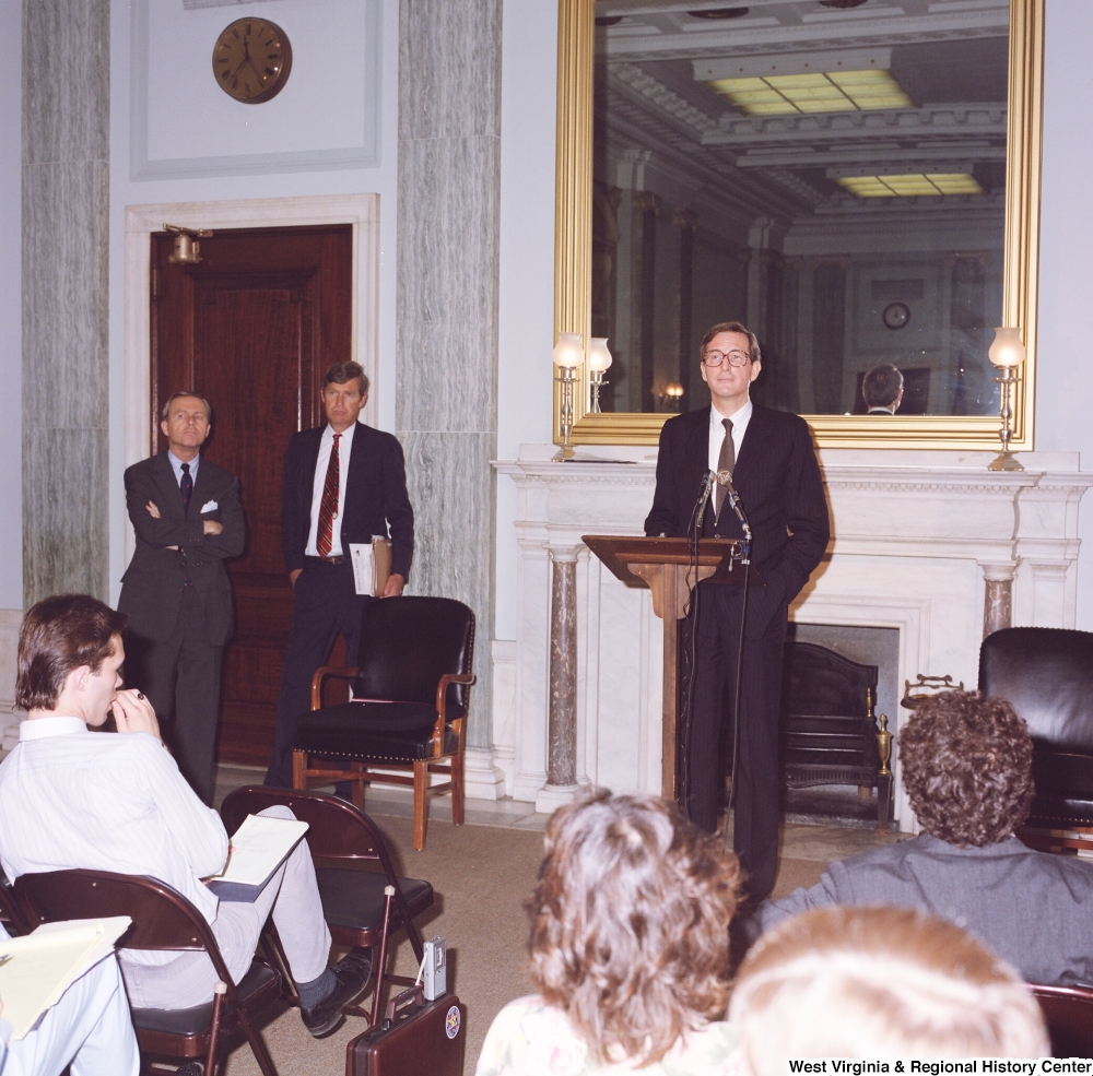 ["This color photograph shows Senator John D. (Jay) Rockefeller speaking in a room in front of a seated audience."]%