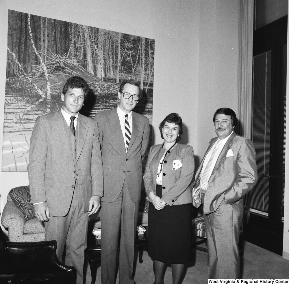 ["Senator John D. (Jay) Rockefeller stands with three unidentified individuals in his office."]%