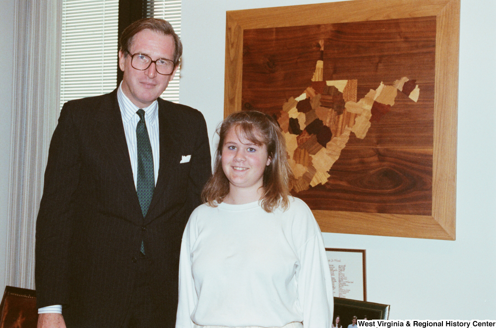 ["Senator John D. (Jay) Rockefeller stands next to an unidentified young woman in his office."]%