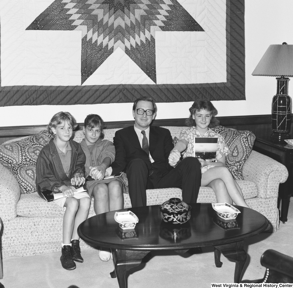 ["Three young and unidentified students sit on a couch with Senator John D. (Jay) Rockefeller in his Washington office."]%