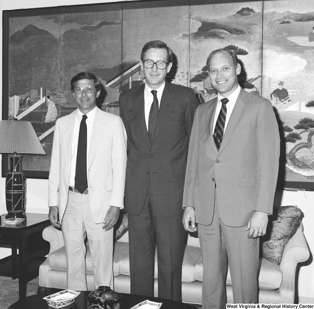 ["Senator John D. (Jay) Rockefeller stands between two unidentified men in his office."]%