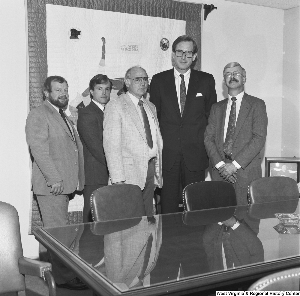 ["Senator John D. (Jay) Rockefeller stands with four unidentified men in his office."]%