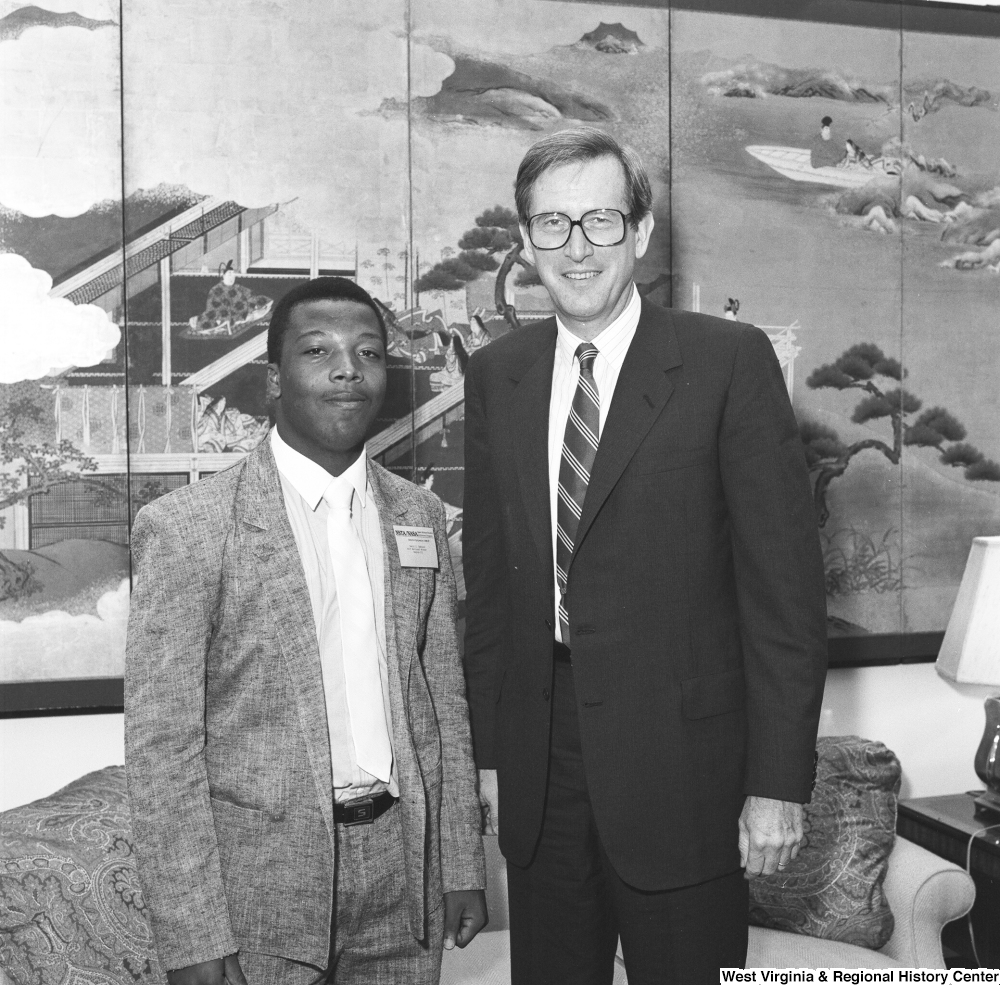 ["Senator John D. (Jay) Rockefeller stands next to an unidentified man who wears a NSTA/NASA badge."]%