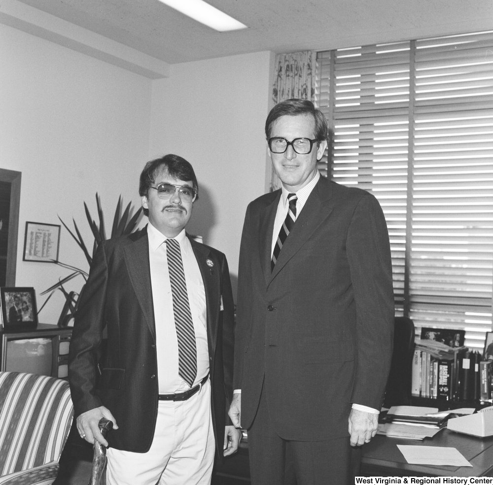 ["Senator John D. (Jay) Rockefeller stands for a photograph in his office with an unidentified man wearing an Elks Lodge pin that reads \"Just Say No: Elks\"."]%
