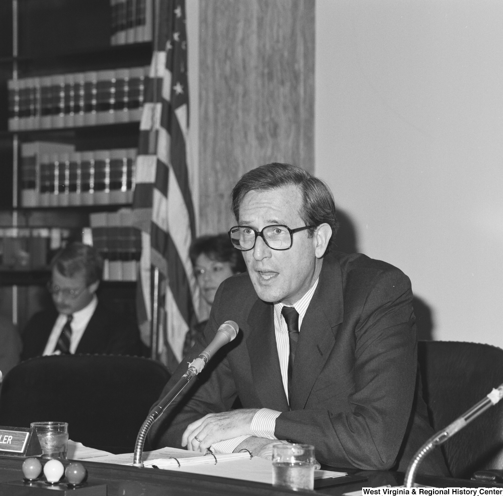 ["Senator John D. (Jay) Rockefeller speaks into the microphone at a Senate committee hearing."]%