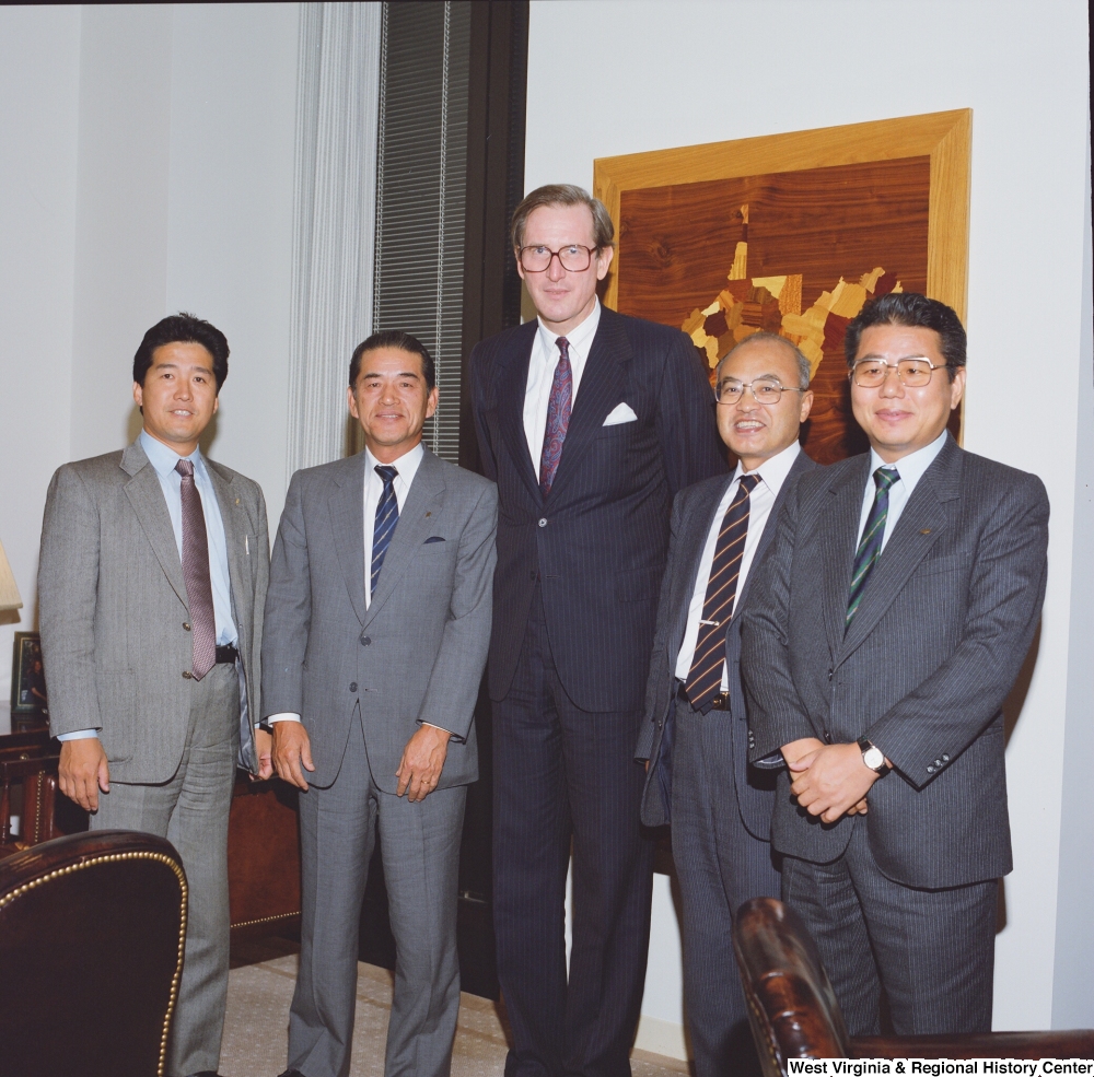 ["Senator John D. (Jay) Rockefeller stands with four members of a Japanese delegation in his office."]%