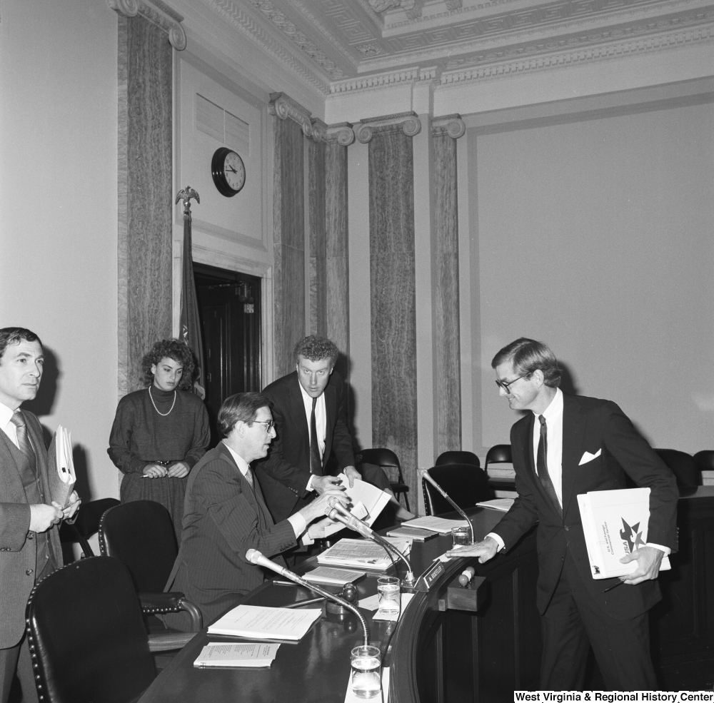 ["Senator John D. (Jay) Rockefeller takes papers from an adviser before a Senate committee hearing."]%