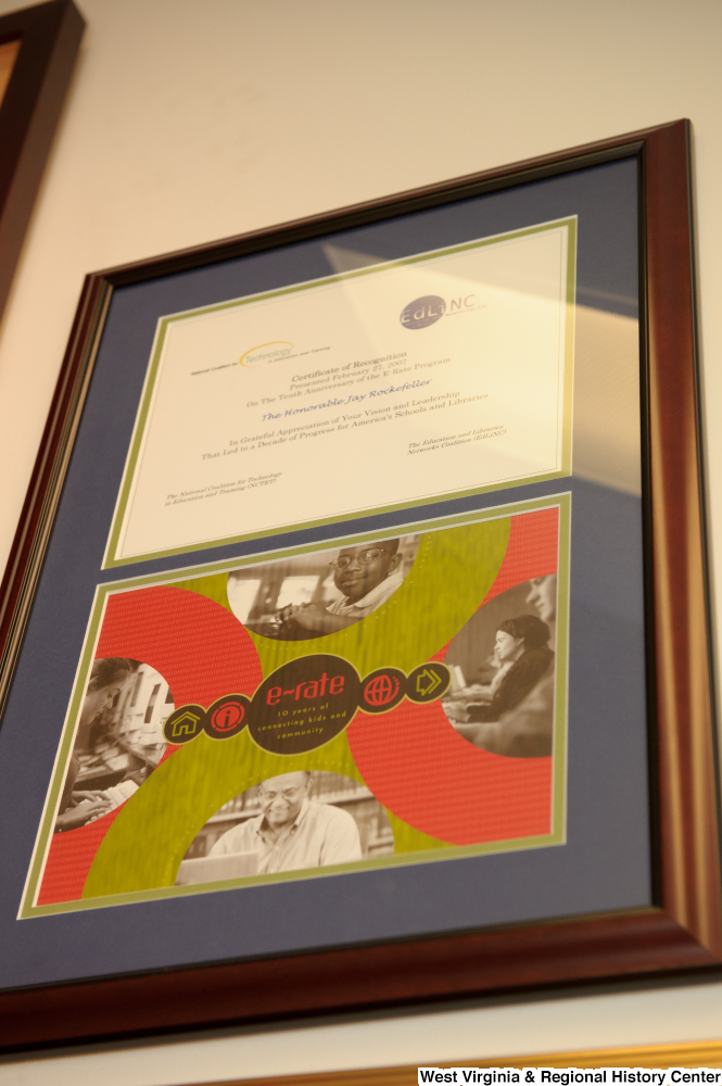 ["A framed certificate celebrating the E-Rate Program's 10th anniversary hangs on a wall in Senator John D. (Jay) Rockefeller's office."]%