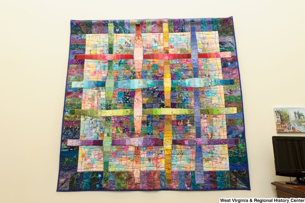 ["A colorful checkerboard quilt hangs on a wall in Senator Rockefeller's office."]%