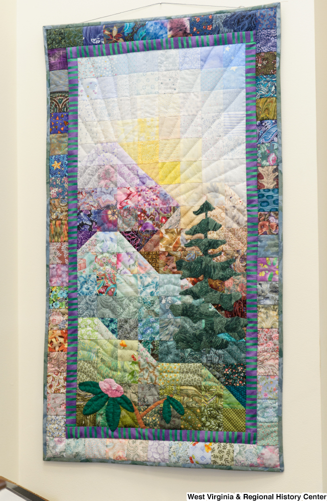 ["A colorful quilt with a nature scene on it hangs in Senator John D. (Jay) Rockefeller's office."]%