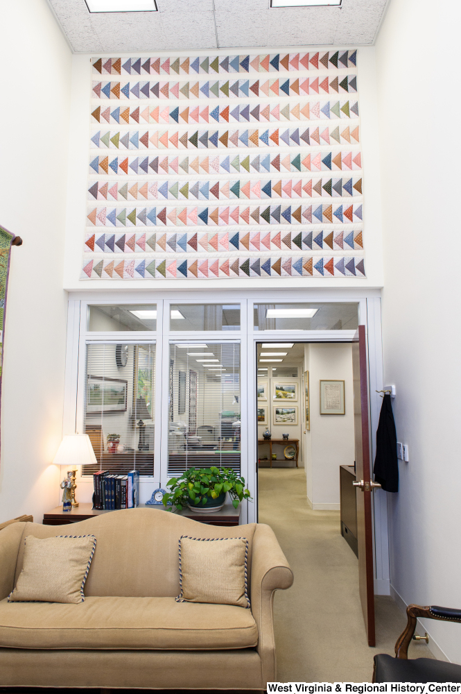 ["A large triangle quilt hangs up on a wall in Senator John D. (Jay) Rockefeller's office."]%