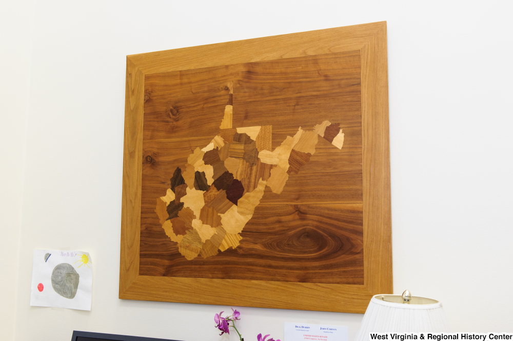 ["A wooden West Virginia hangs on a wall in Senator Rockefeller's office."]%