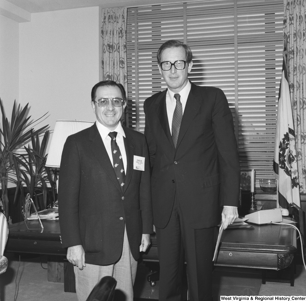 ["Senator John D. (Jay) Rockefeller stands in his office with an unidentified individual."]%