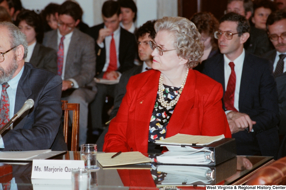 ["An unidentified woman sits on the panel at a Senate conference event."]%