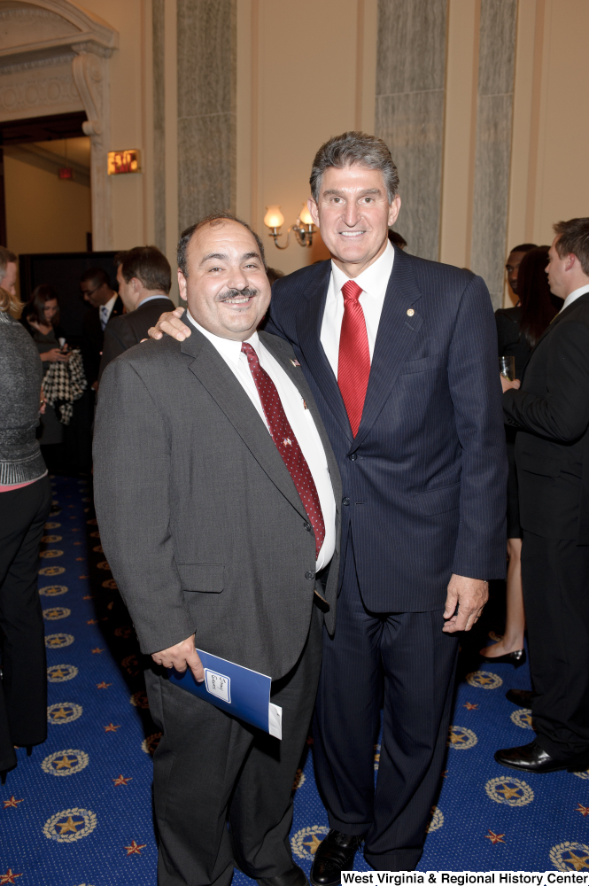 ["Senator Joe Manchin stands with an unidentified man after his swearing-in ceremony."]%