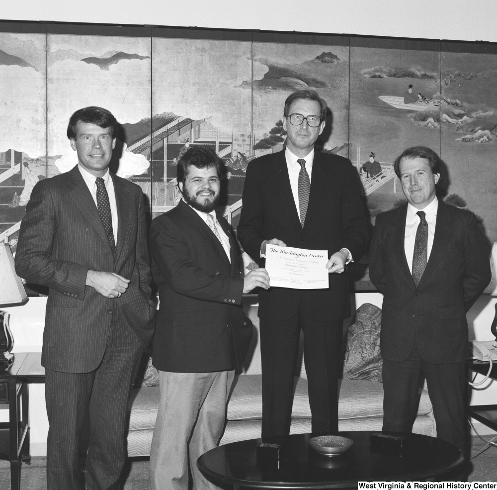 ["Senator John D. (Jay) Rockefeller stands with three unidentified men and holds a certificate from The Washington Center."]%