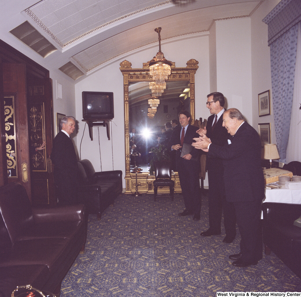 ["Senator John D. (Jay) Rockefeller, Senator Al Gore, and former Senator Jennings Randolph wait outside and greet Senator Robert C. Byrd as he exits a room."]%